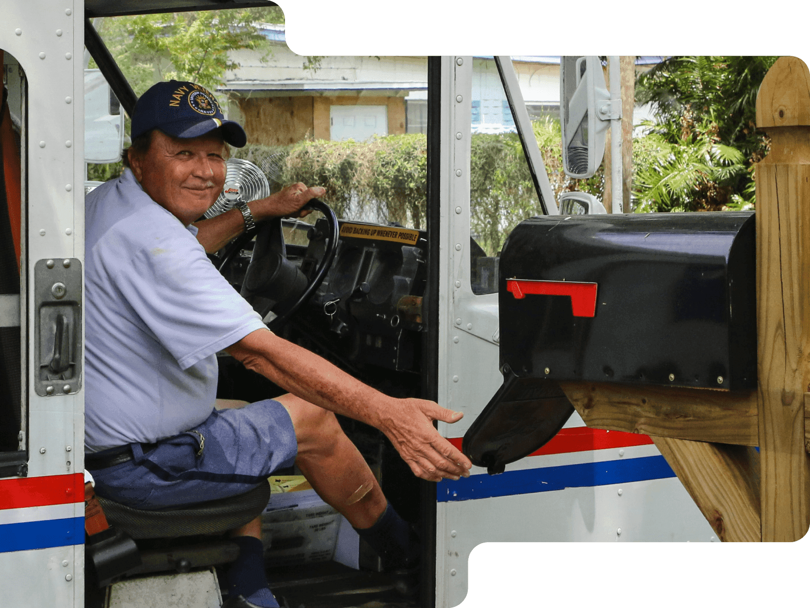 Driver looking out the door of a truck delivering mail
